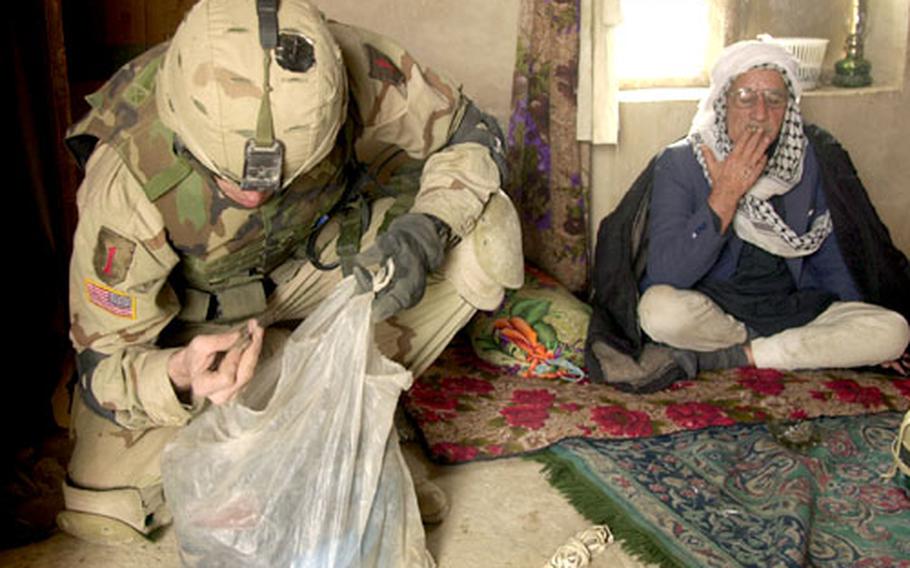 An Iraqi man in the tiny village of Talal Sabot seems indifferent as a Staff Sgt. Kevin White searches the man&#39;s home for weapons. Acting on a tip, the unit arrested an arms dealer nearby in January, but found nothing this week on a follow-up search.