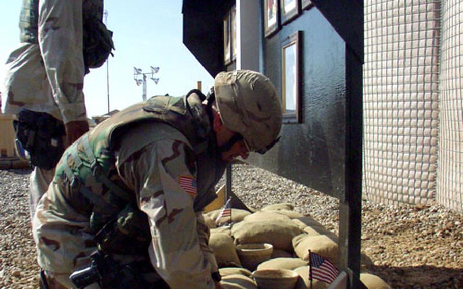 1st Sgt. Brent Jurgersen plants a flag last November at Forward Operating Base MacKenzie, Iraq, at a memorial wall for 1st Squadron, 4th Cavalry Regiment soldiers killed in action. Jurgersen lost a leg and suffered serious head wounds in a Jan. 26 grenade attack on his Humvee, his second near-fatal injury in Iraq.