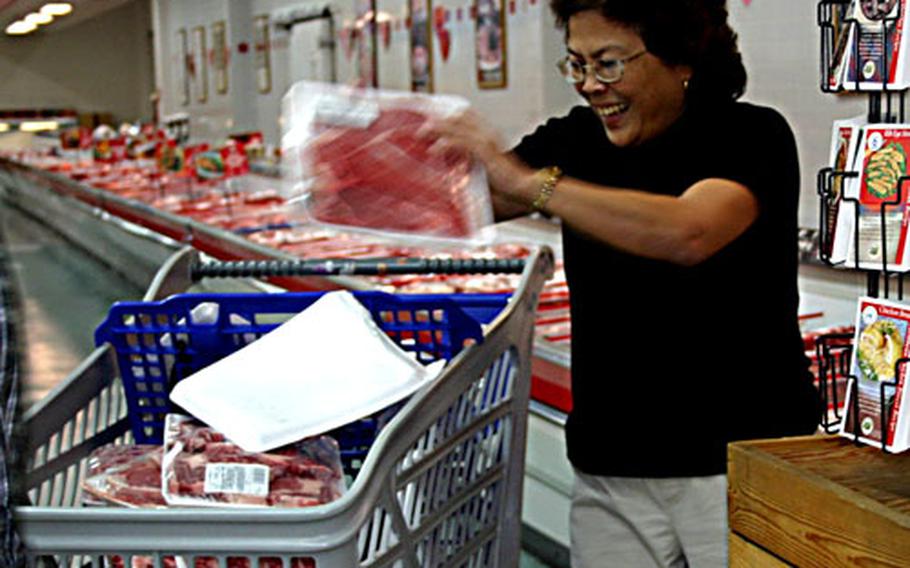 Catherine Flores McCollum loads her shopping cart with meat Friday during the three-minute shopping spree she won at the Orote Point Commissary on U.S. Naval Base Guam.