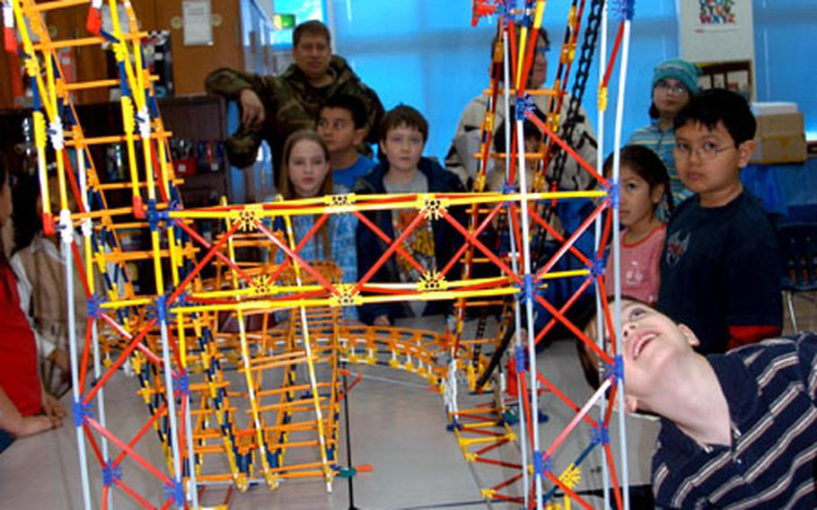 Third- and fourth-graders at Cummings watch the student-built roller coaster crest the top of a hill riding a pulley.