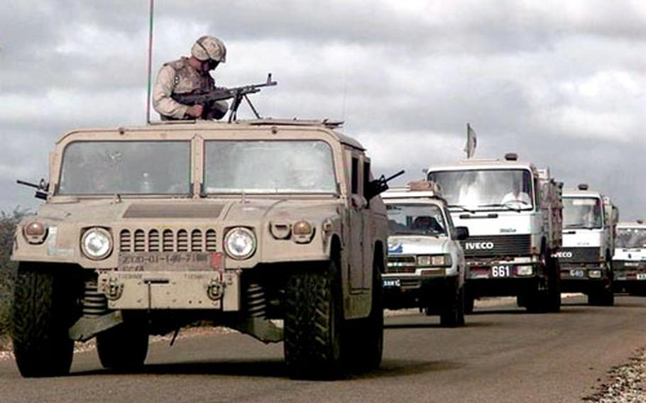 A Marine mans an M-60 machine gun out the top turret of a Humvee in this file photo. The Army is budgeting $224 million for 360 up-armored Humvees and 1,705 heavy chassis Humvees in 2006.