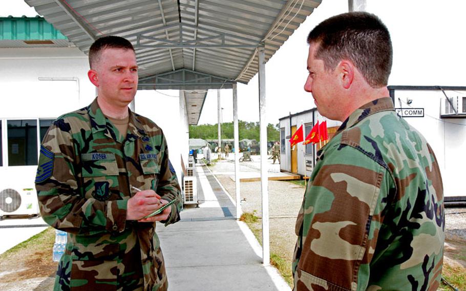 Senior Master Sgt. Donald Koser, left, CSF-536 command historian from Misawa Air Base, Japan, discusses relief effort experiences at Royal Thai Naval Air Base in Utapao, Thailand, with Navy Petty Officer 1st Class Shawn Eklund, a combat photographer deployed from Fleet Combat Camera Atlantic, Norfolk, Va.