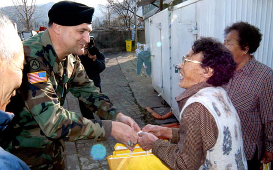 Army Col. Donald J. Hendrix hands a Lunar New Year gift of canned tuna to a resident near the Walker Army Heliport. Friday’s gift giving is part of the U.S. military’s drive to foster good relations. Hendrix is commander of the Area IV Support Activity in Taegu, South Korea.