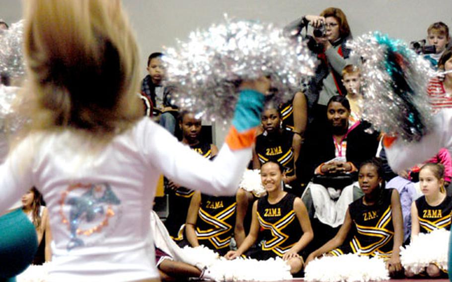 Miami Dolphin cheerleaders perform for their young counterparts from the Zama American High School and the Youth Center cheer squads during a cheerleading performance and clinic.