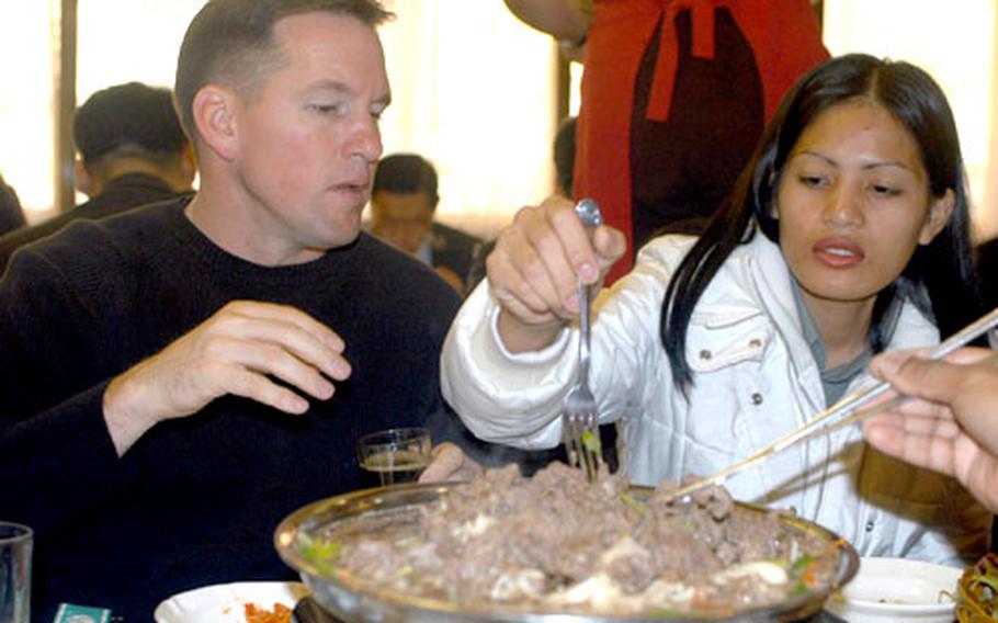 Master Sgt. Mark Clark and his wife, Jorimil, try some authentic Korean food in Uijongbu.