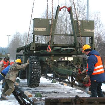 Workers at the Vilseck military railhead position the back chassis of a Palletized Load System truck on a rail car Wednesday as the specialized vehicles of the 41st Transportation Company were sent on the first leg of their journey to Iraq. The 41st soldiers will be reunited with their vehicles in Kuwait in March.