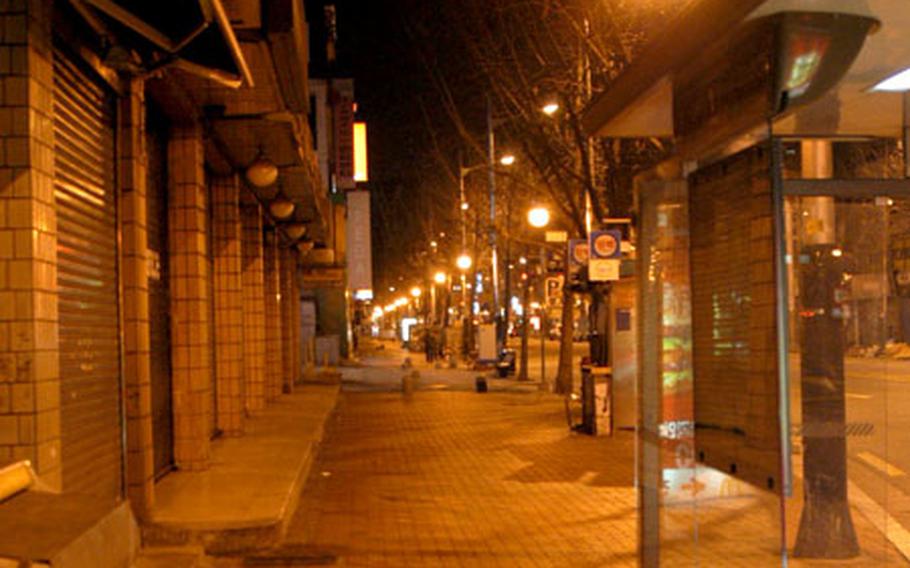 The main drag in Itaewon is deserted at 5 a.m. in the final minutes before the nightly curfew is lifted. Some civilian and contract workers complain the policy in unnecessary and intrusive.