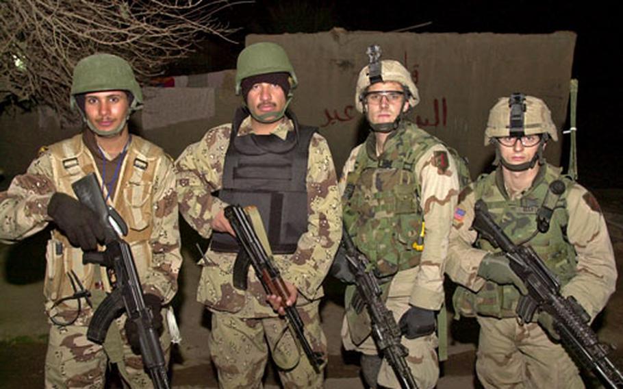 Sgt. Daniel Veach, second from right, and Spc. Michael Martin, right, pose with Iraqi counterparts after a long night of seaching houses in Ad-Dawr, outside Tikrit.