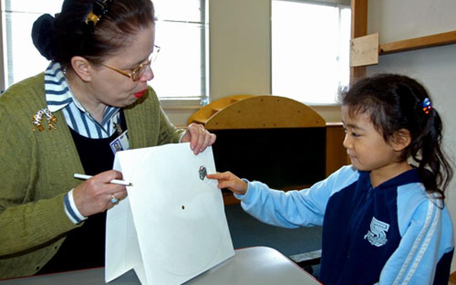 Isabel Polak, EDIS speech language pathologist, asks Melody Matsueda, 4, to name different objects during a screening last week at Misawa Air Base, Japan. EDIS and Department of Defense Dependents Schools saw about 30 to 40 children last week during free screenings to learn whether any of the children might have developmental delays or disabilities.