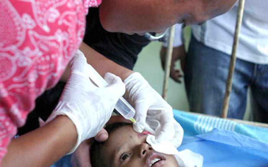 Field medical technician Petty Officer 2nd Class Ian Porter injects painkiller above a Sri Lankan child’s eye at the Point Pedro Hospital in Jaffna, Sri Lanka, before U.S. Navy doctors stitch a gash the boy received from a fall. The medical team from U.S. Naval Hospital Okinawa deployed to the region in support of the humanitarian relief mission following the Dec. 26 tsunami.