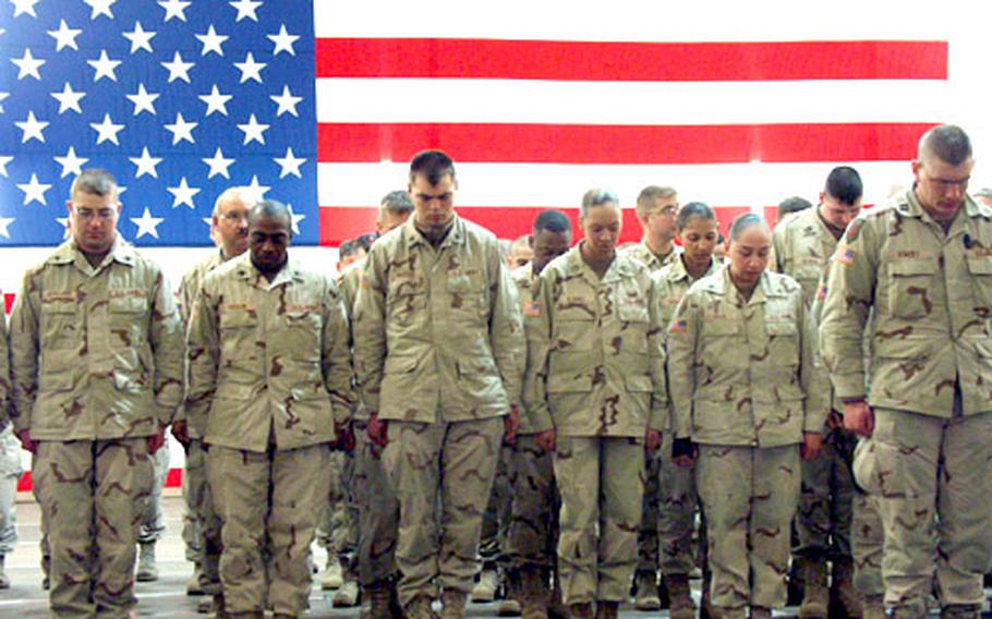 As a chaplain gives an invocation, soldiers from the 1st Infantry Division&#39;s headquarters staff bow their heads in prayer at a brief welcome-home ceremony just after midnight Thursday in Würzburg, Germany.