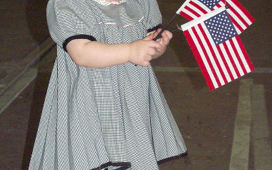 Dressed in her best clothes and waving the Stars and Stripes, Lauren Stanley, 14 months, awaits the return of her father, Master Sgt. Chris Stanley of the 1st Infantry Division&#39;s headquarters company, from Iraq. Lauren was only two months old when he left, said her mother, Karen Stanley.