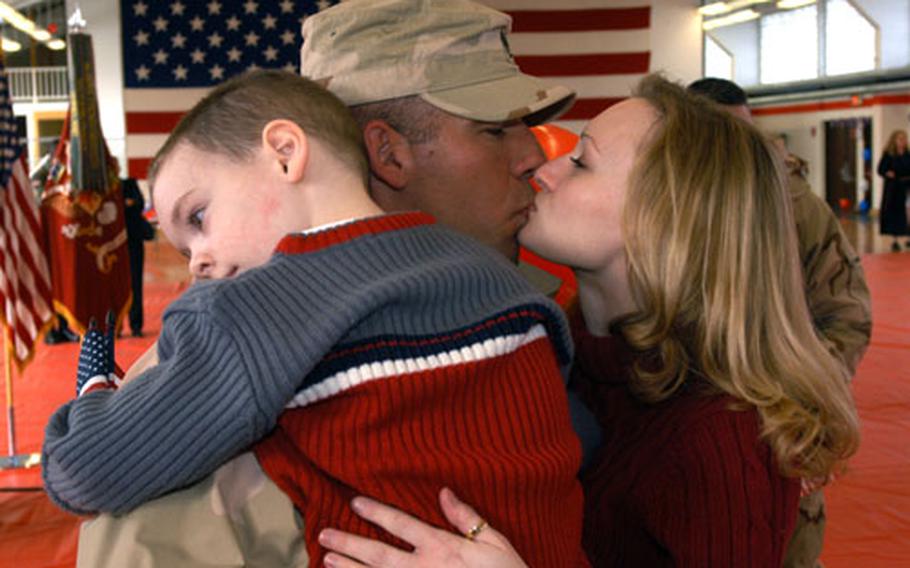 Staff Sgt. David Miller, 32, of Tampa, Fla., kisses Daisy Bradley while holding their 4-year-old son, Christian. Miller returned home Friday from Iraq with the 66th Transportation Company.
