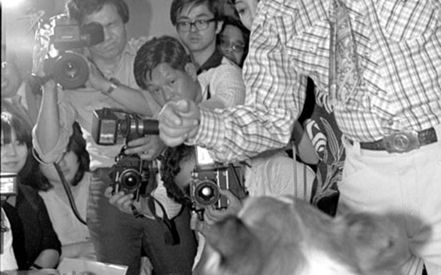 Lassie and trainer Rudd Weatherwax meet the press in Tokyo in June, 1979.