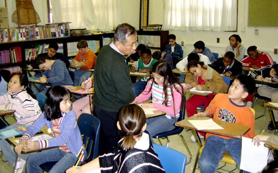 At Taegu American School in Taegu, South Korea, Chin Cheol-bo, the school’s Korean language and culture teacher, looks over students as they write letters of support and thanks to soldiers of South Korea’s Zaytun Brigade serving in Iraq.