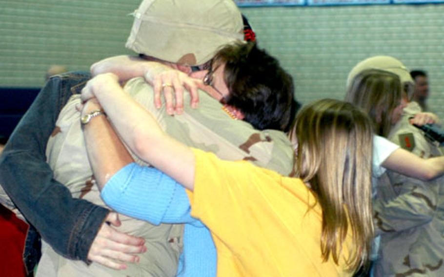 Staff Sgt. James Thomas is embraced by wife Lynn, daughter Annie and son James Sunday in Vilseck, Germany, during a return ceremony for the 2nd Battalion, 63rd Armor Regiment.