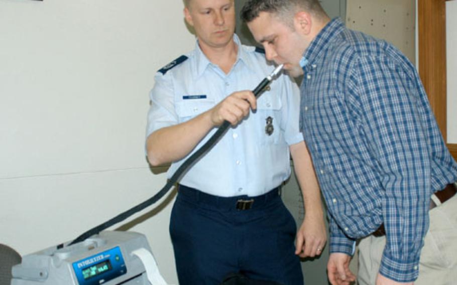 Master Sgt. Timothy Fearney, 374th Security Forces Squadron, conducts a blood-alcohol test on Staff. Sgt. Jason Pringle during a demonstration Wednesday at Yokota Air Base, Japan.