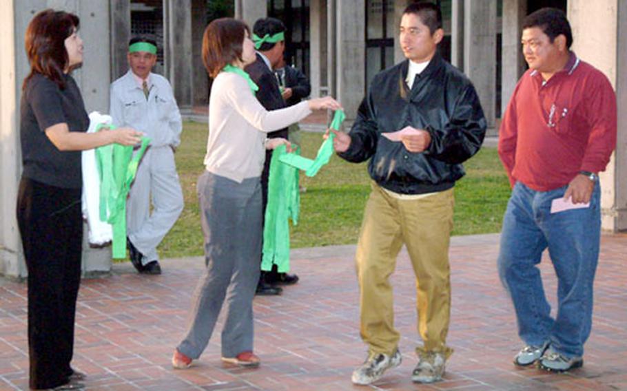 Rally organizers hand out green headbands Wednesday to supporters of construction of a Marine Corps air station in northeast Okinawa.