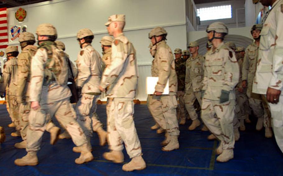 Soldiers from 1st Battalion, 6th Field Artillery Regiment and Headquarters and Headquarters Company, 1st Infantry Division, march into the Warner Barracks welcome home center on Thursday.