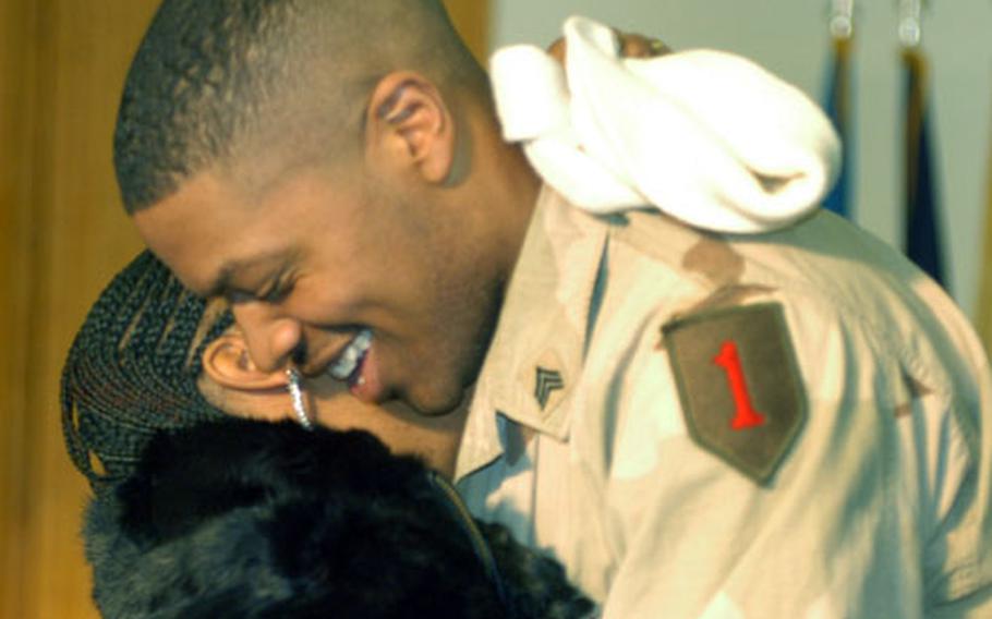 Sgt. Adon Jones, 1st Battalion, 6th Field Artillery, right, hugs his wife, Jamicka, during the return ceremony.