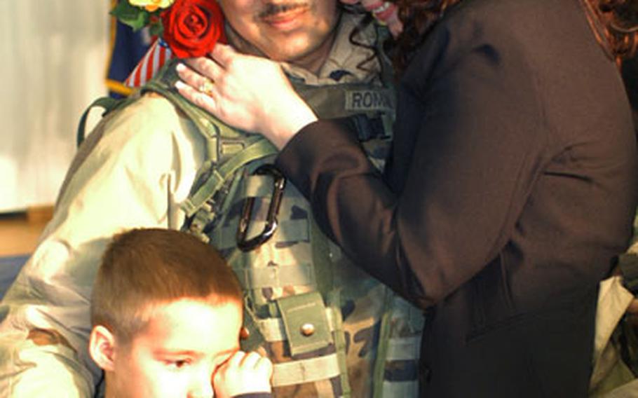 Pfc. Richard Roman, Battery C, 1st Battalion, 6th Field Artillery, center, hugs his family — wife Tamira Roman and son Anthony — Thursday on Warner Barracks. Roman was one of 80 Bamberg, Germany-based soldiers who returned from Iraq.