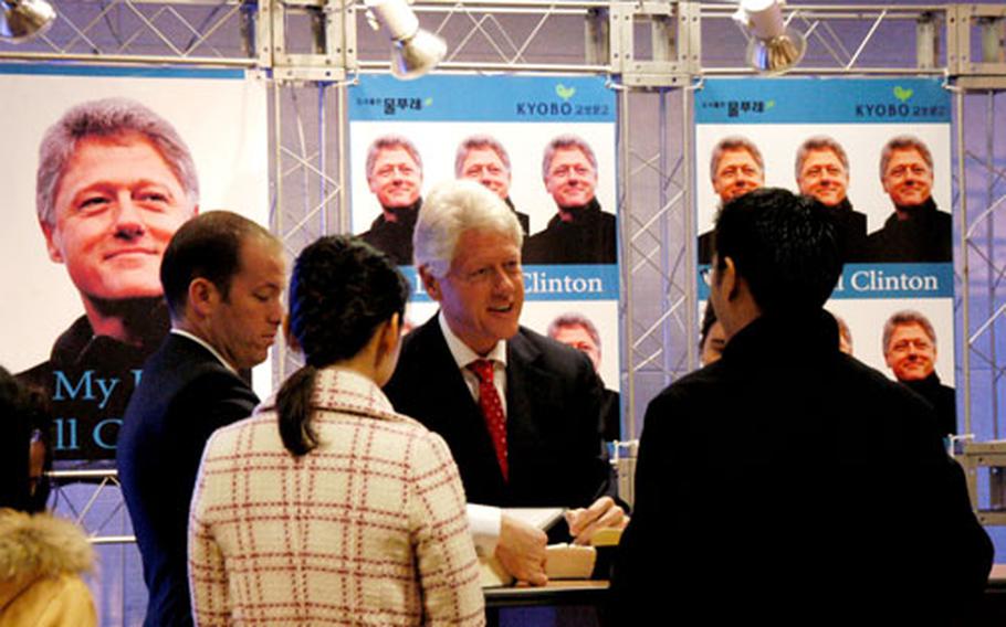 pnw# 50p sb Former President Clinton talks with a group of Koreans during Friday&#39;s book signing in Seoul. Clinton&#39;s two-day stop in Korea came on the heels of a tour he and former President George Bush made to the tsunami-ravaged parts of Asia. Clinton said he would donate some of the proceeds of his book sales to the tsunami relief efforts.