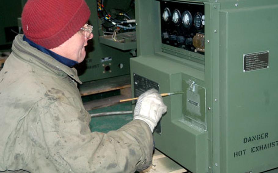 Clyde Kimber, an employee of the U.S. Army’s Combat Equipment Battalion-Hythe at RAF Hythe, England, paints a repaired generator ready for shipment to Iraq for use by troops.