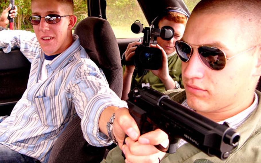 Lance Cpl. Martin R. Harris aims a toy pellet gun out the window, while Cpl. Trevor M. Carlee, center, records Lance Cpl. Joel Abshier during the filming of "Killing The Tension," a short film shot by Carlee on Okinawa.