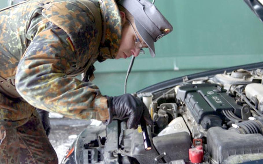 Sebastian Paulig takes a close look under the hood of a car at the main gate at Cambrai-Fritsch Casern in Darmstadt, Germany, on Monday. Paulig is a German soldier from the 233rd Mountain Ranger Battalion in Mittenwald, Germany.