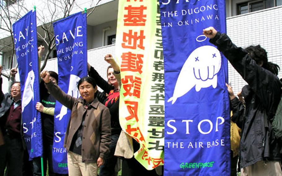 Opponents of the Marine air station planned for the waters off northeast Okinawa carry banners urging protection of the dugong, a saltwater manatee.