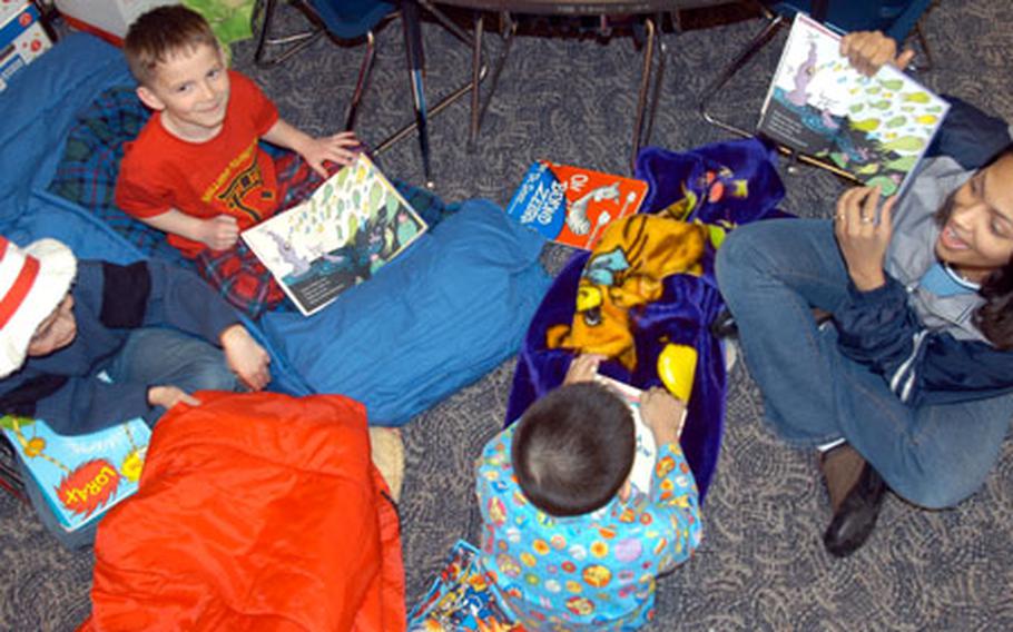Teneka Mason, a military spouse at Misawa Air Base, Japan, reads a Dr. Seuss book Wednesday to Sean Atrsada, left, Caleb Rhoton, top, and Stephen Lampa at Sollars Elementary School.