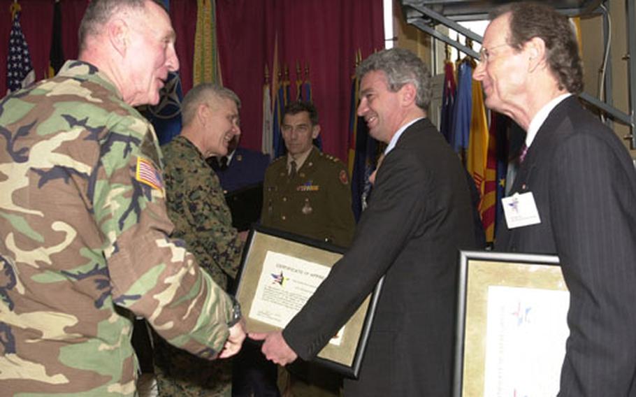From left, Army Maj. Gen. Walter Wojdakowski and Marine Lt. Gen. Edward Hanlon Jr. congratulate Lt. Col. Fernand Guth (in uniform), Philippe Collart and Peter Arts at Daumerie Casern near Chievres Air Base in Belgium after presenting them letters of appreciation for their work in marking the 60th anniversary of World War II events during the past year.