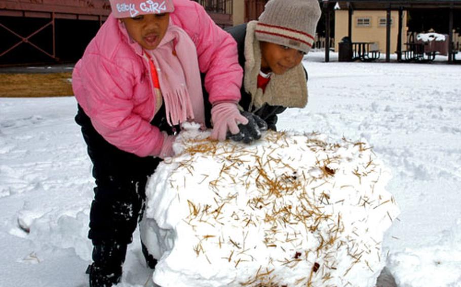 Five-year-old Arian Garvin, left, and her 7-year-old brother, Elijah, build a snowman Friday at Yokota Air Base, Japan.