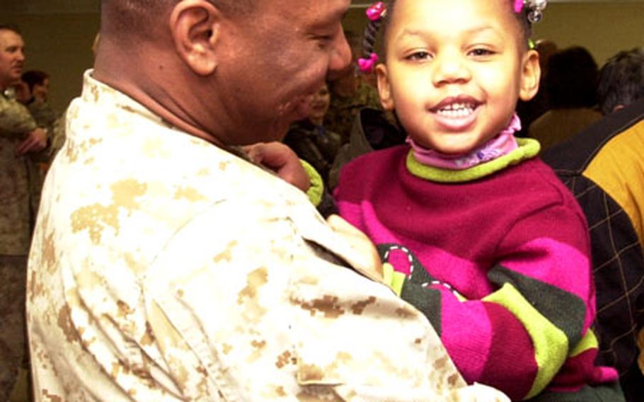 Capt. Burrell Parmer holds his daughter at Kadena Air Base early Sunday morning after returning from Iraq.