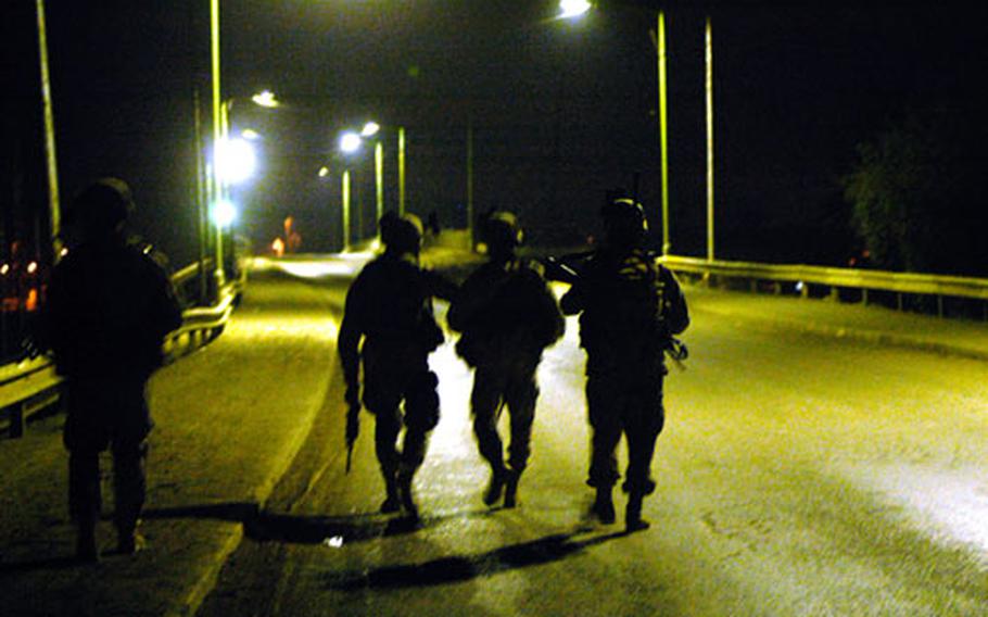 Soldiers from Company B, 1st Battalion, 30th Infantry Regiment at Forward Operating Base Gabe check a bridge in Baqouba on Sunday night for security risks.