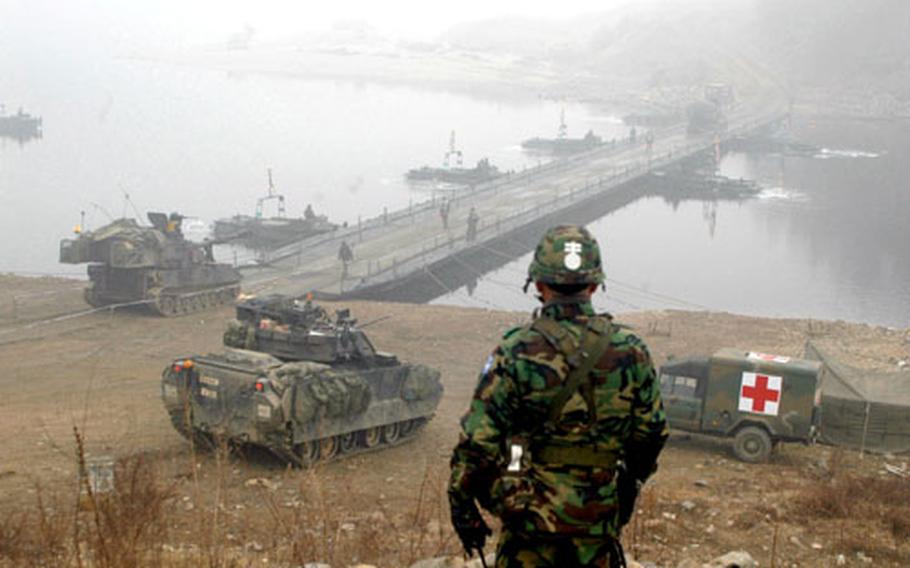 A South Korean soldier watches vehicles from 2nd ID&#39;s 1st Heavy Brigade Combat Team cross the Imjin River.