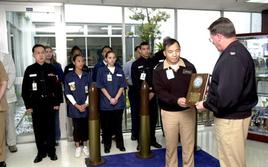Capt. Rick Becker, right, commanding officer of U.S. Naval Hospital Okinawa, presents the 2004 Department of Defense Safety Award for Technology to Lt. Cmdr. Thinh Ha, department head for the hospital’s Pharmacy Services, during a short ceremony Tuesday.