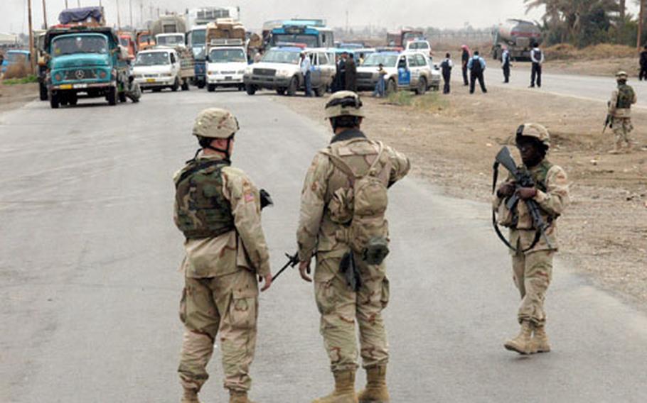 U.S. soldiers secure the road while the bomb is destroyed near the Mushada Bridge. The cordon area ensured that soldiers and Iraqi civilians remained a safe distance from the controlled blast.