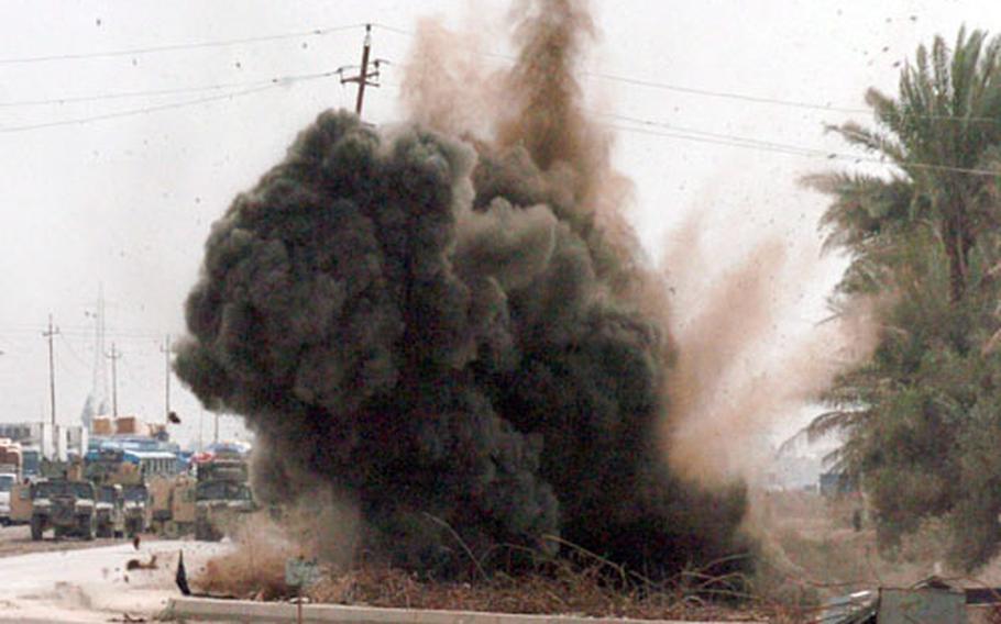 An Army Explosive Ordinance Disposal team detonates the roadside bomb found by members of 1st Battalion, 13th Armored Regiment, 3rd Brigade, 1st Armored Division. Minutes later, an unseen insurgent detonated a second bomb a few yards away as soldiers moved closer to inspect the initial detonation site.