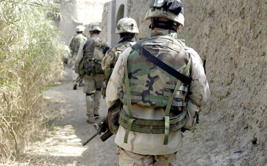 Soldiers from 1st Battalion, 10th Infantry Regiment, 42nd Infantry Division enter a village near Buhriz, Iraq, on Tuesday while searching for weapons, explosives and insurgents during Operation Rock Hammer.
