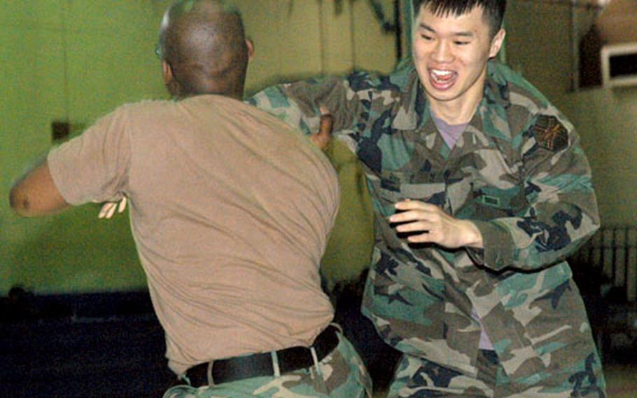 During hand-to-hand combat training at Taegu, South Korea, last month, Sgt. Kareen Richardson executes a basic takedown move called the "drop knee sayo" on Cpl. No Sang-myun.