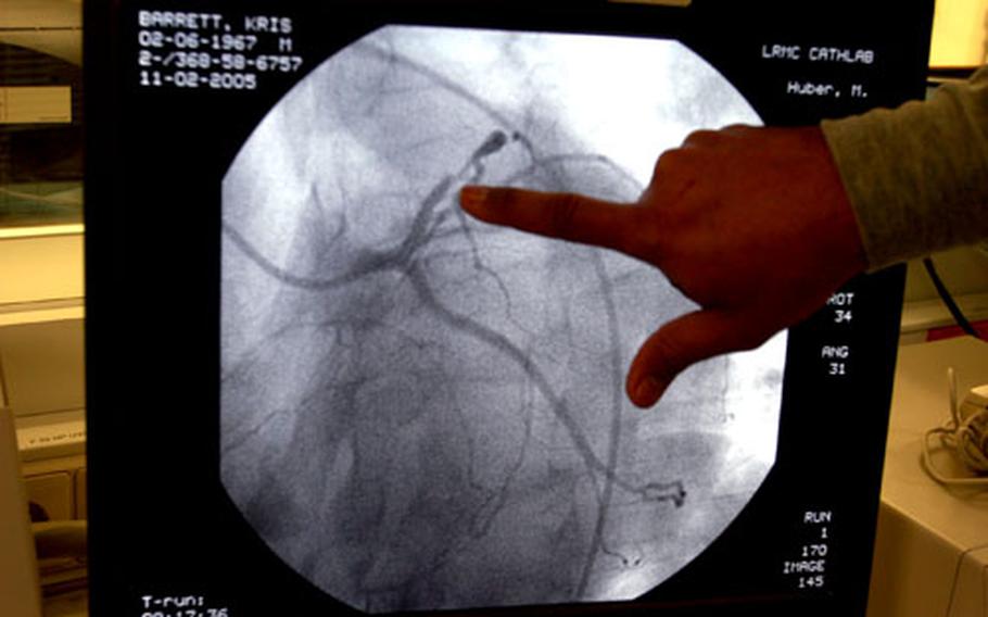Dr. (Maj.) Michael Huber, a cardiologist at Landstuhl Regional Medical Center in Germany, looks at the result of a coronary angiogram, a type of x-ray of the heart, of a patient recommended for heart surgery.