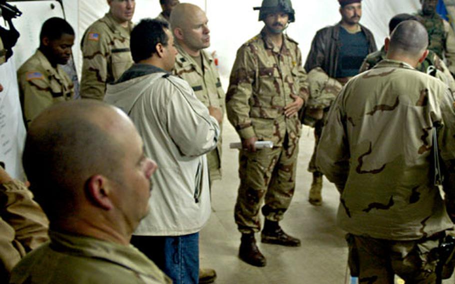 Lt. Col. Rob Roggeman, center, commander of 2nd Battalion, 69th Armored Regiment, and Col. Abdullah Hassoni Abdullah, center right, commander of the 204th Iraqi Army Battalion, go over plans at Forward Operating Base Scunion in Baqouba, Iraq, for a raid on Thursday night.