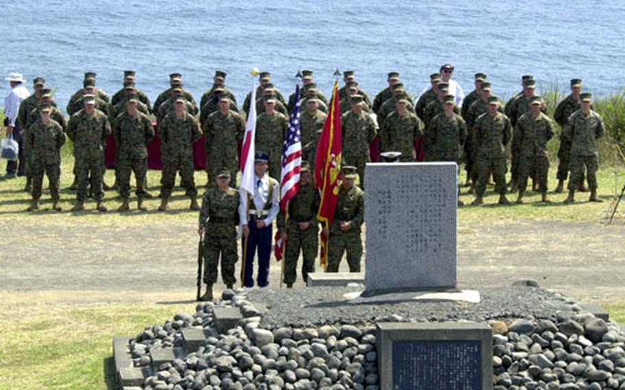 A ceremonial platoon of Marines and the joint U.S.-Japan color guard stand before the Reunion of Honor monument.