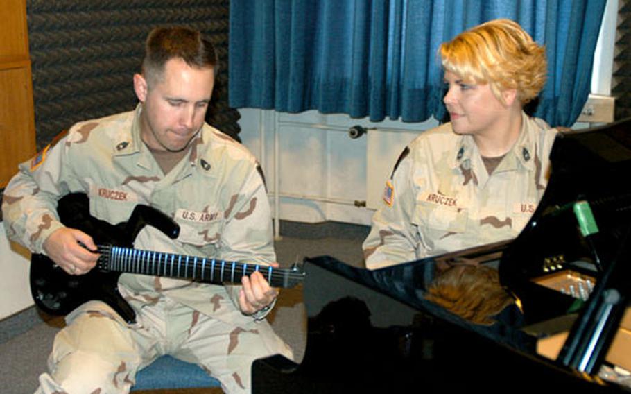 Sgts. 1st Class James Kruczek and Dion Kruczek sing one of the 20 songs they wrote or compiled for a compact disc that tells the stories of soldiers on a deployment to Iraq.