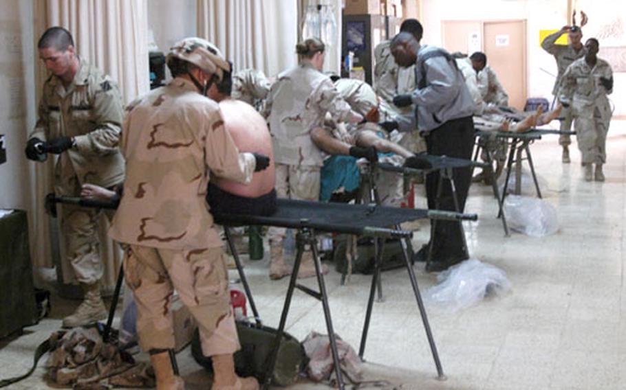 Medics from Company C, 203rd Forward Support Battalion, 3rd Brigade Team, 42nd Infantry Division, treat the wounded at the Teal Medical Facility at Forward Operating Base Warhorse after the car-bomb attack.