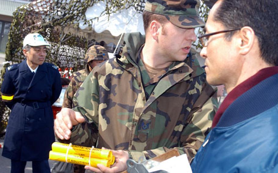 Staff Sgt. Jonathan Homer, an Explosive Ordnance Disposal expert with 35th Civil Engineer Squadron at Misawa, holds fake dynamite during an Improvised Explosive Device discussion that was part of an exercise Tuesday between JASDF 3rd Air Wing guard and transportation troops and 35th Fighter Wing security forces.