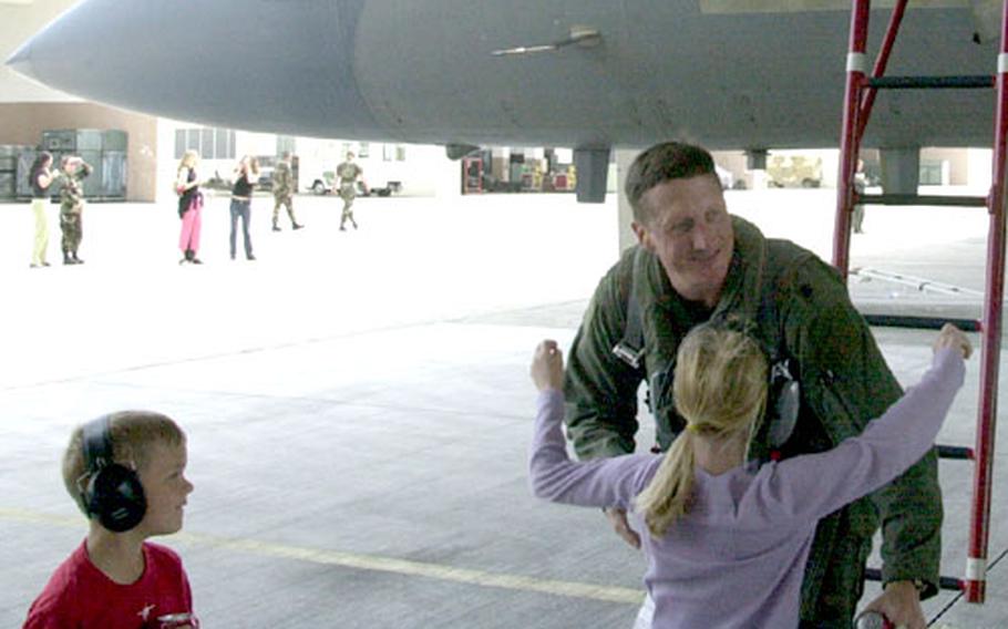 Lt. Col. Jeff "Lenny" Gustafson of the 67th Fighter Squadron hugs one of his four children Wednesday as he returns from a month at Red Flag combat exercises.