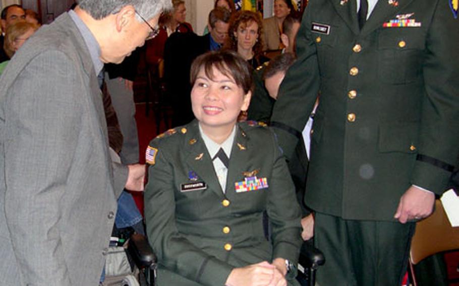 Army Maj. Tammy Duckworth, who lost both legs in an RPG attack in Iraq in November, speaks with Sen. Daniel Akaka, D-Hawaii, before testifying to the Senate Veterans Affairs Committee on Thursday. At right is her husband, Capt. Bryan Bowlsbey.