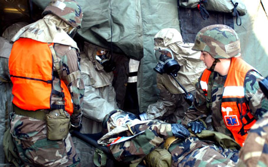 Airmen from the 374th Medical Group move a "victim" of a simulated chemical weapons attack into a patient decontamination area.